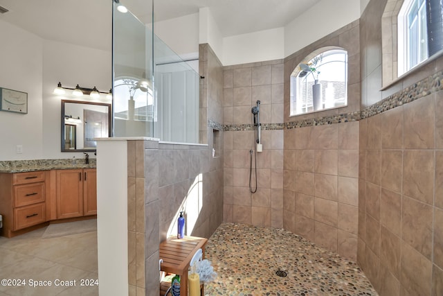 bathroom with vanity, tile patterned floors, and a tile shower