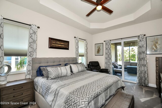 bedroom with access to exterior, ceiling fan, and a raised ceiling