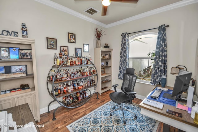 office with crown molding, visible vents, a ceiling fan, wood finished floors, and baseboards