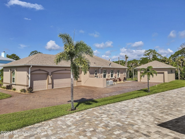 view of front of home with a garage and central AC