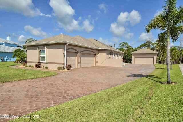 view of front facade with a garage, driveway, a front yard, and stucco siding