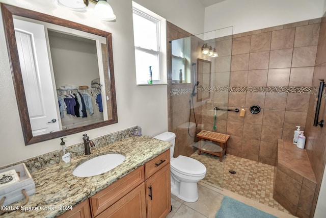 full bathroom with a walk in shower, tile patterned flooring, vanity, and toilet