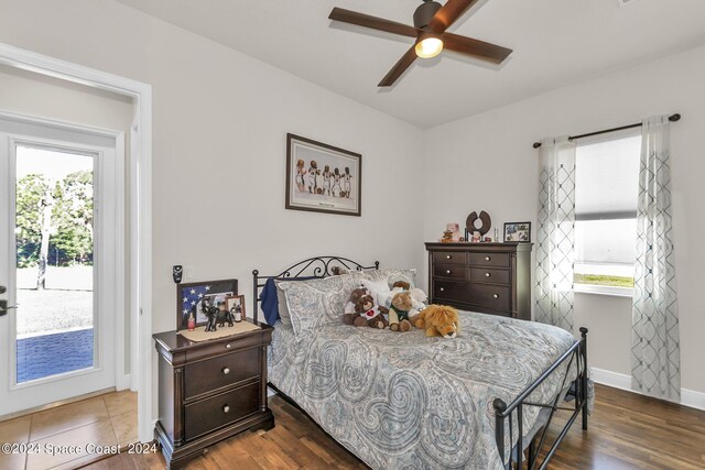 bedroom with multiple windows, hardwood / wood-style floors, and ceiling fan