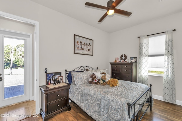 bedroom featuring access to exterior, multiple windows, and wood finished floors