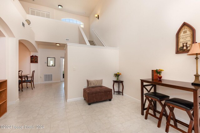 interior space featuring a high ceiling and light tile patterned floors