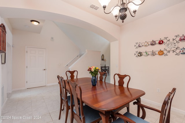 dining room with light tile patterned floors, an inviting chandelier, and lofted ceiling