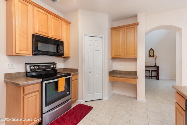 kitchen with dark countertops, stainless steel electric range oven, black microwave, and arched walkways