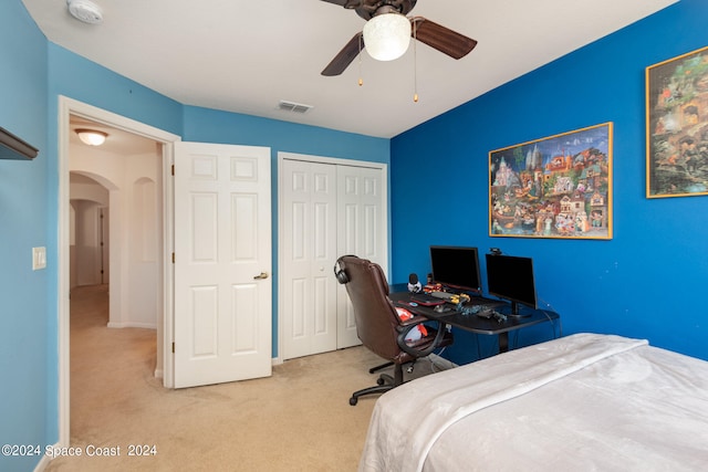 bedroom with a closet, light colored carpet, and ceiling fan