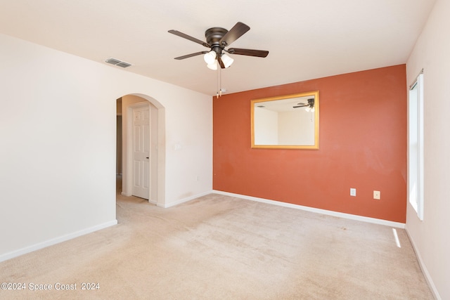 spare room with light colored carpet and ceiling fan