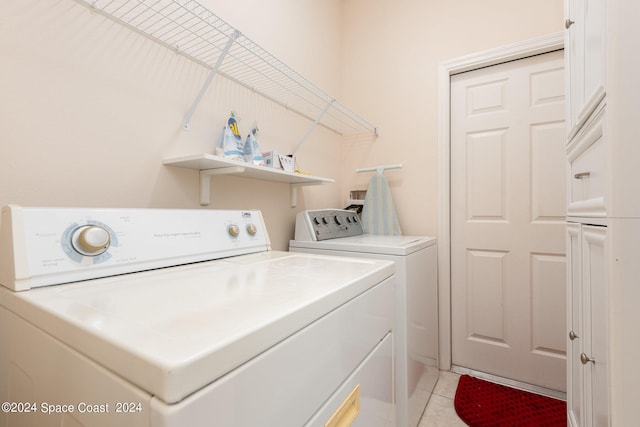 laundry room with washer and dryer and light tile patterned floors