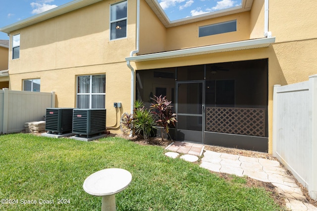 rear view of property with fence, central AC, and stucco siding