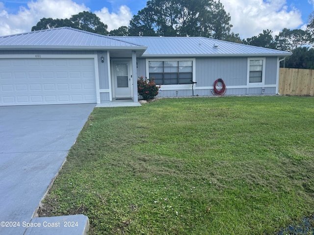 single story home featuring a front yard and a garage