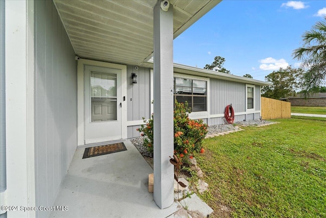 property entrance with a lawn