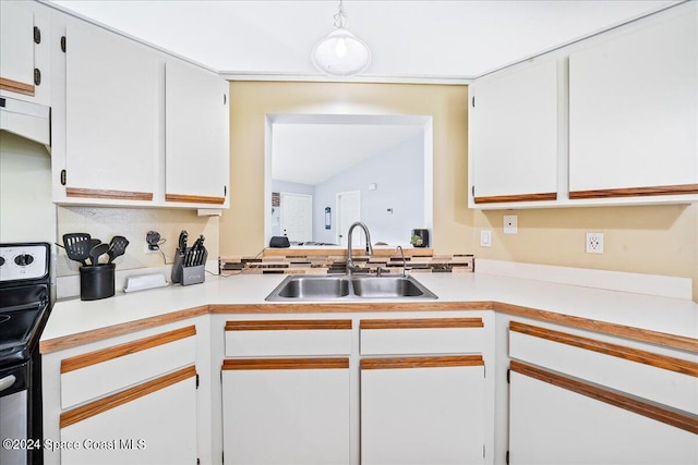 kitchen with sink, white cabinetry, and stainless steel range