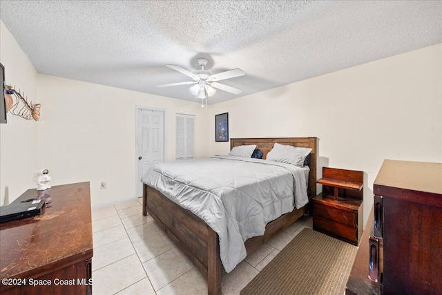 bedroom featuring light tile patterned flooring, a textured ceiling, and ceiling fan