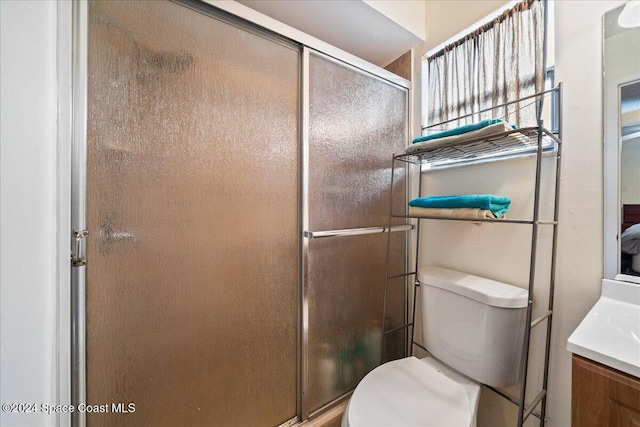 bathroom featuring toilet, walk in shower, and vanity