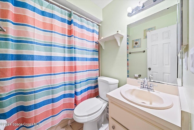 bathroom with vanity, tile patterned flooring, toilet, and walk in shower