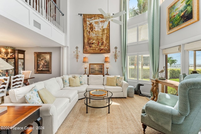 living room with ceiling fan, a towering ceiling, and decorative columns