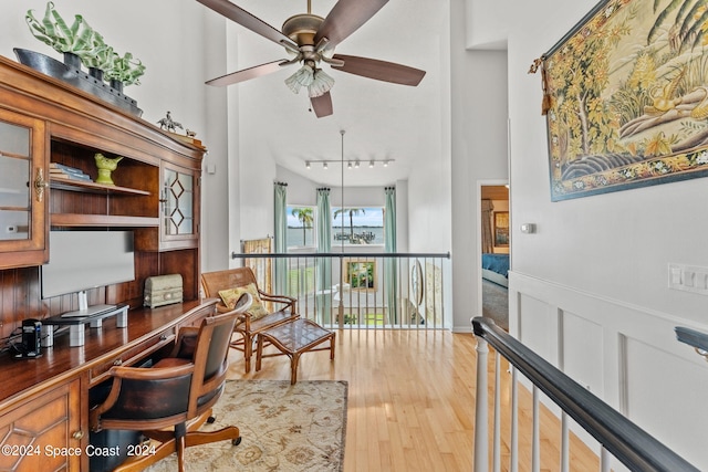 office featuring ceiling fan, a high ceiling, and light hardwood / wood-style floors