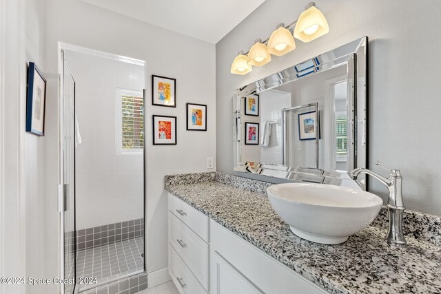 bathroom with tiled shower and vanity