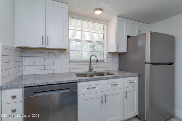 250 Berkshire Ln, Melbourne, FL 32935 - kitchen with appliances with stainless steel finishes, a sink, light stone counters, and white cabinets