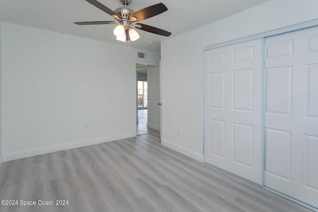 unfurnished bedroom featuring light hardwood / wood-style flooring, ceiling fan, and a closet