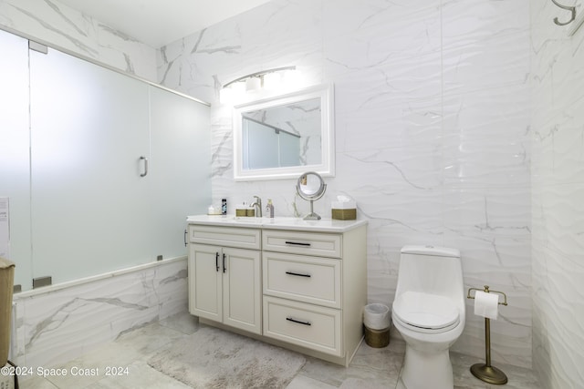 bathroom with tile walls, marble finish floor, vanity, and toilet