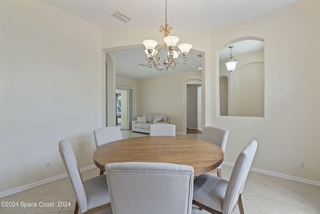 dining space featuring light tile patterned floors and an inviting chandelier