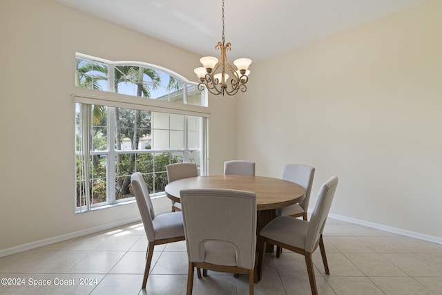 tiled dining space featuring a healthy amount of sunlight and a chandelier