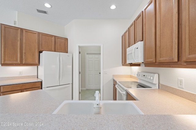 kitchen with tile patterned floors, white appliances, and sink