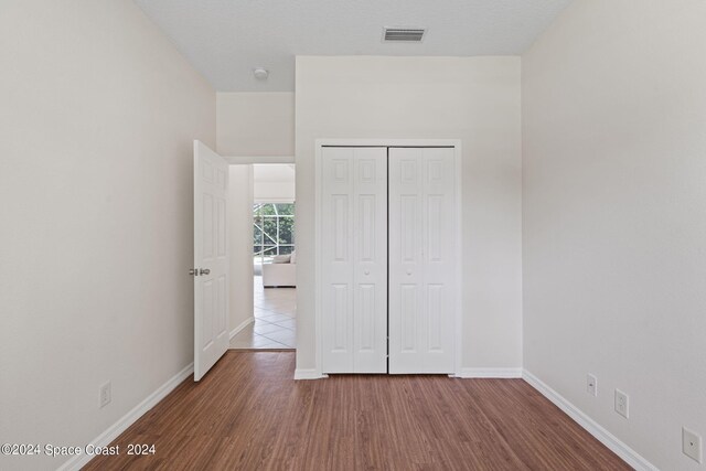 unfurnished bedroom with a closet and hardwood / wood-style floors