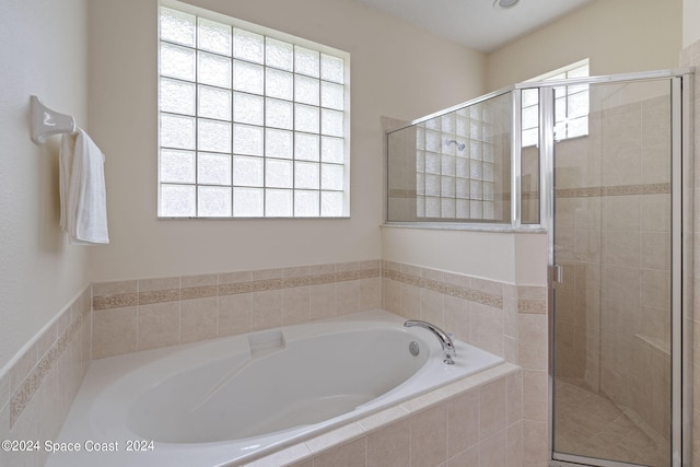 bathroom featuring independent shower and bath