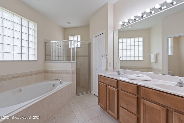 full bathroom with a healthy amount of sunlight, separate shower and tub, vanity, and tile patterned floors