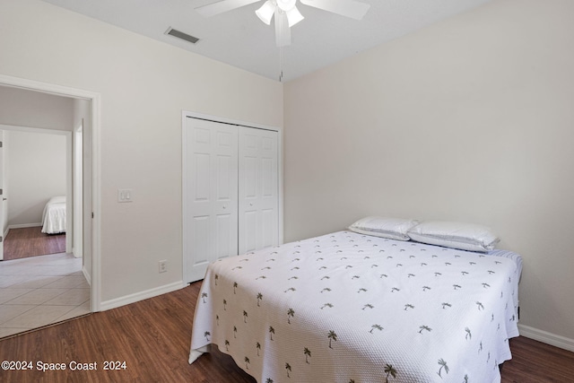 bedroom featuring hardwood / wood-style floors, ceiling fan, and a closet