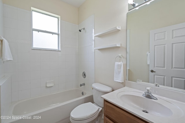 full bathroom featuring tiled shower / bath, vanity, and toilet