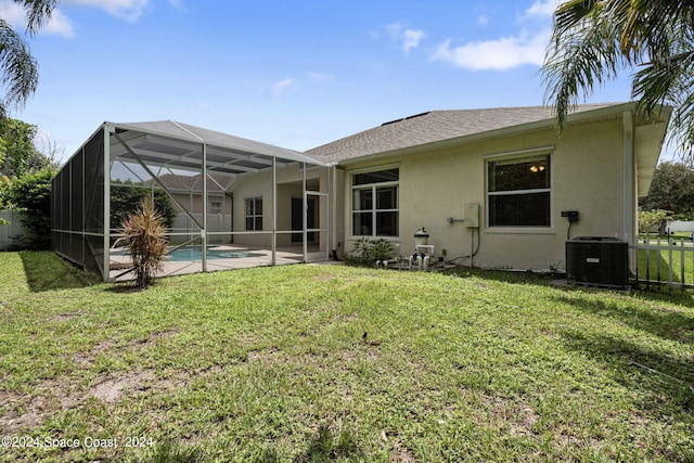 back of house with glass enclosure, central air condition unit, a lawn, and a patio area