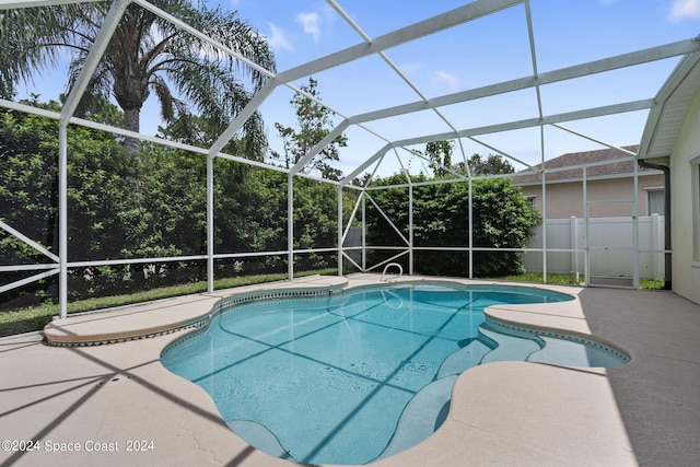 view of pool with a patio area and glass enclosure