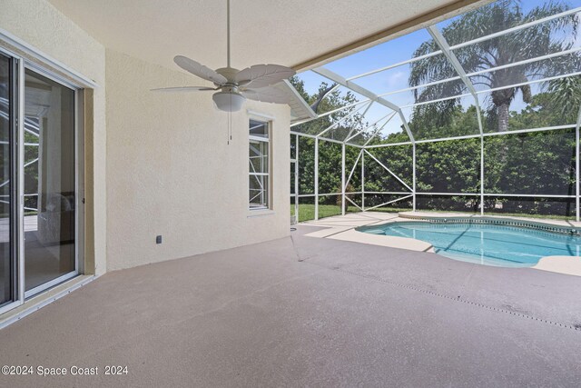 view of pool with ceiling fan, a lanai, and a patio