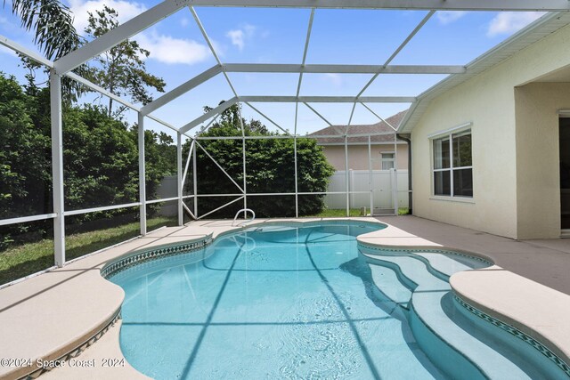 view of pool with a patio and glass enclosure