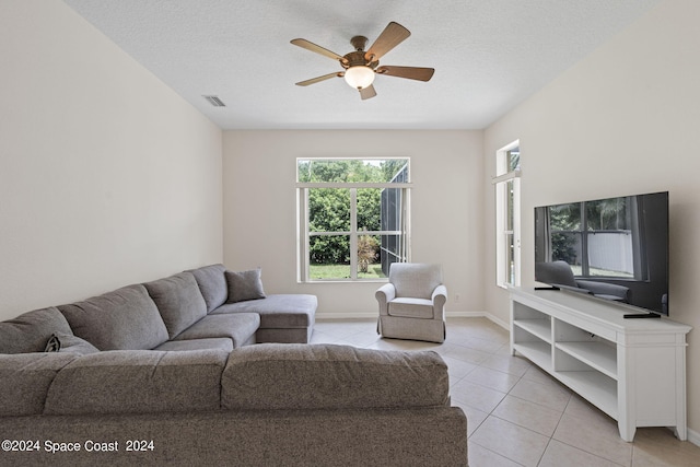 tiled living room featuring a textured ceiling and ceiling fan