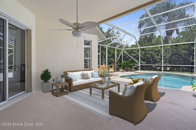 view of pool featuring a lanai, ceiling fan, a patio area, and an outdoor hangout area