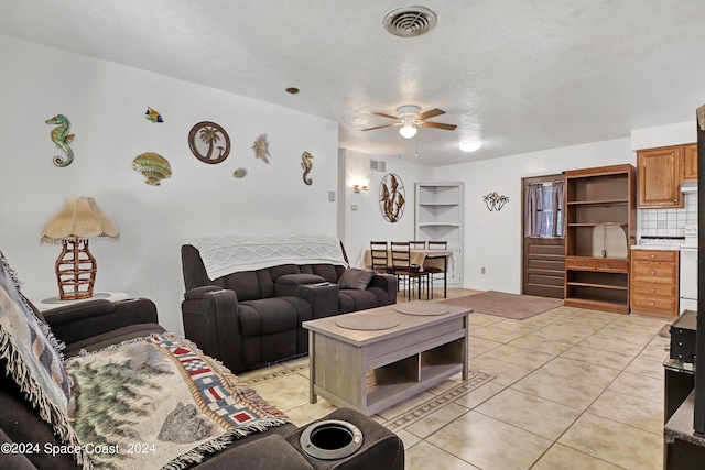 tiled living room with a textured ceiling and ceiling fan