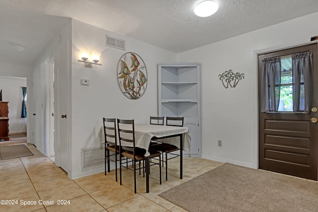 tiled dining area with a textured ceiling