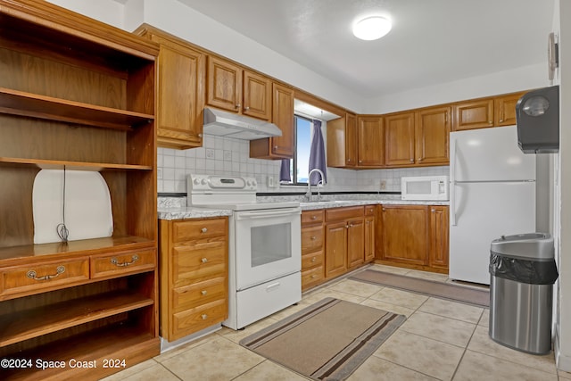 kitchen featuring white appliances, backsplash, light tile patterned floors, light stone counters, and sink