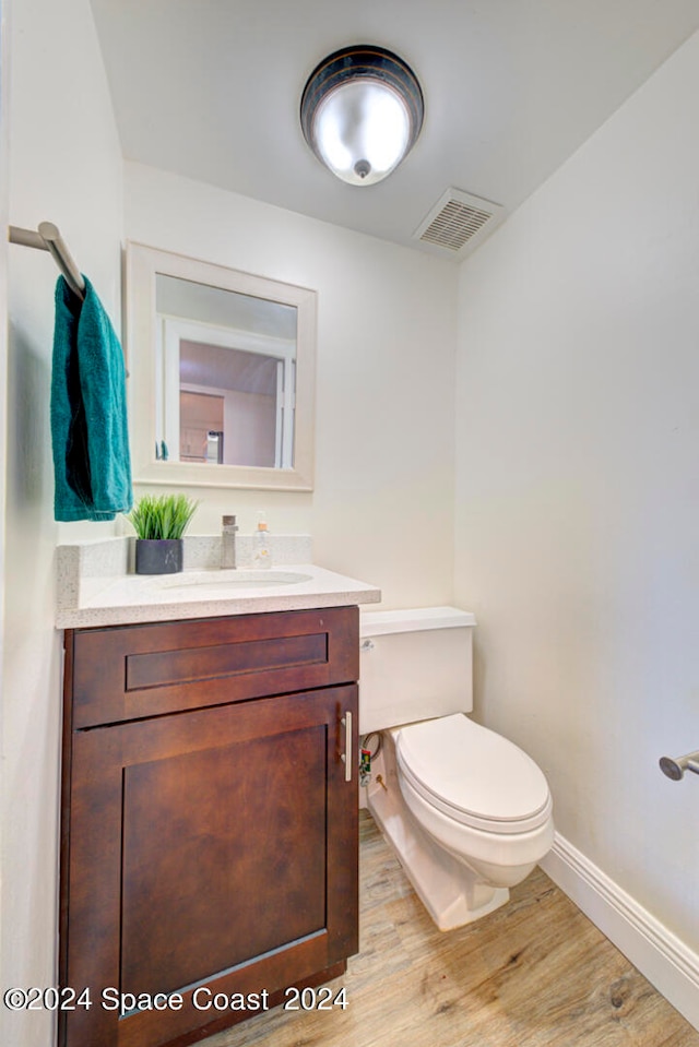 bathroom featuring vanity, toilet, and hardwood / wood-style flooring