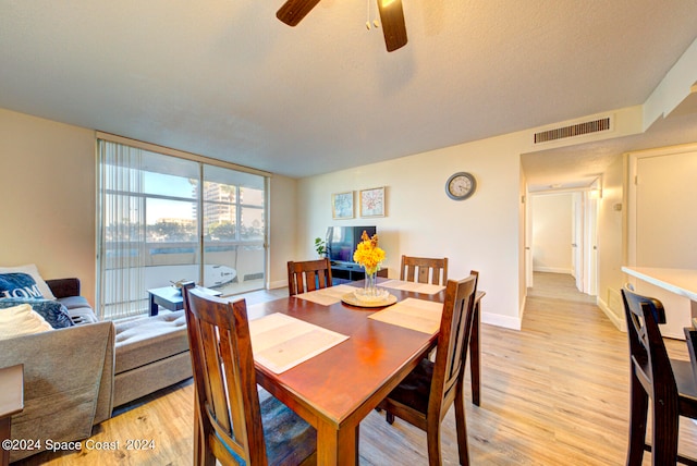 dining space featuring ceiling fan, light hardwood / wood-style floors, and a textured ceiling