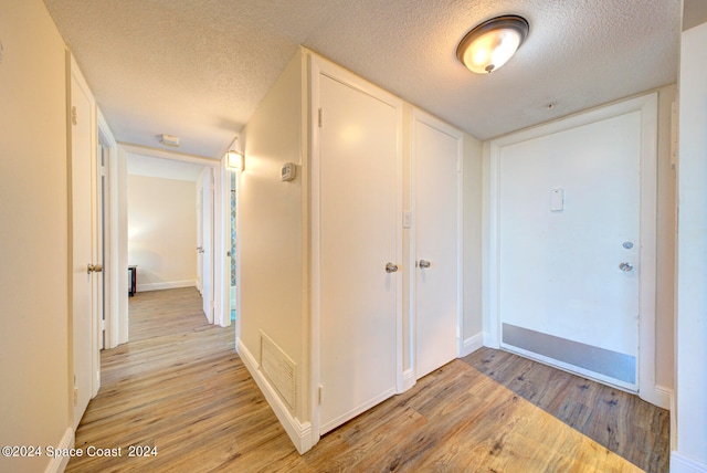 entryway featuring light hardwood / wood-style flooring and a textured ceiling