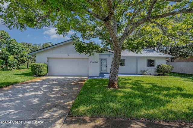 ranch-style home featuring a garage and a front lawn