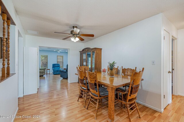 dining room featuring ceiling fan, light hardwood / wood-style floors, and a textured ceiling