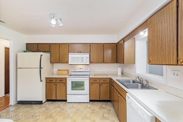 kitchen featuring sink, white appliances, and light hardwood / wood-style floors